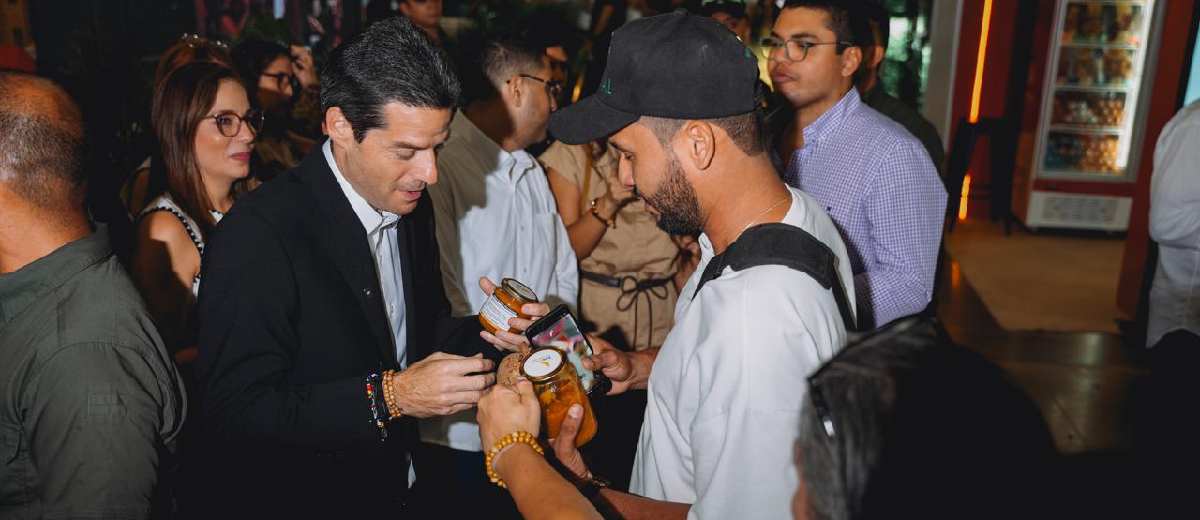Descripción imagen: Ministro recibiendo degustaciones de participantes en la feria gastronómica.
