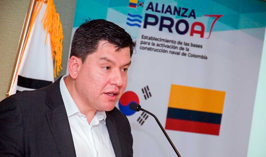 Viceministro de Desarrollo Empresarial (e), Camilo Rivera, vestido de traje, hablando por micrófono al público