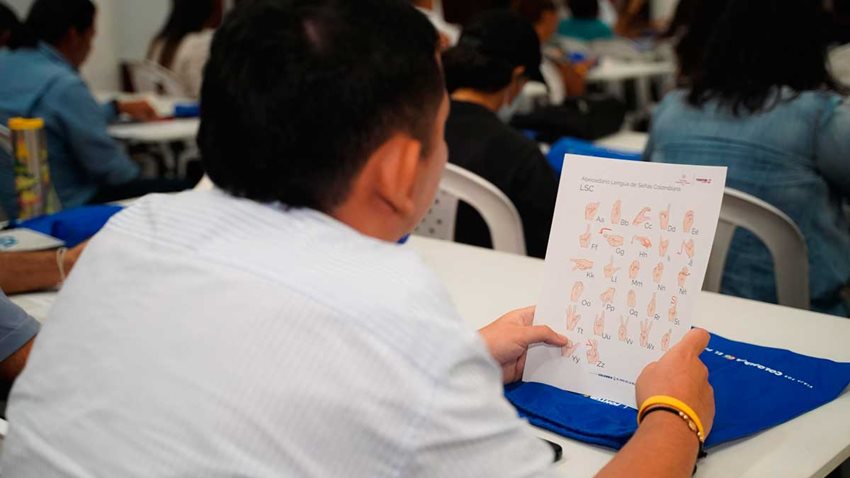 Hombre observando manual de lengua de señas.