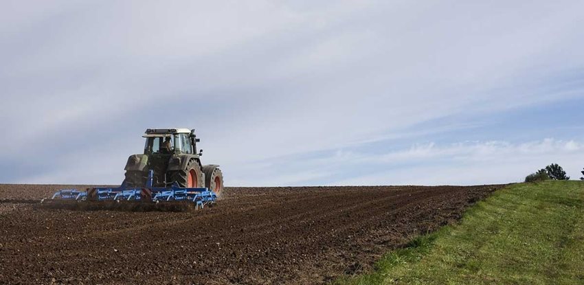 Imagen de un tractor arando un campo de siembra.