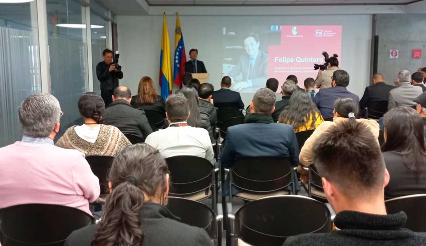 Al fondo, las banderas de Colombia y Venezuela, mientras el viceministro Felipe Quintero le habla al público.