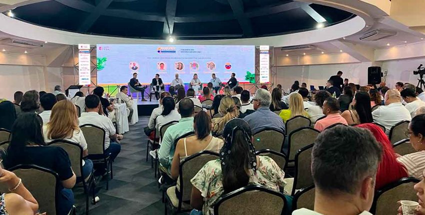 Gran cantidad de personas sentadas escuchando a los conferencistas del evento.