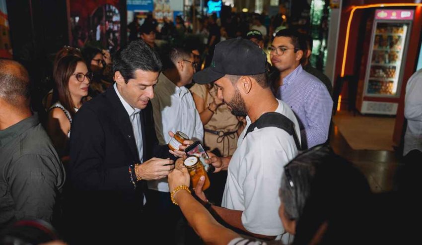 Ministro recibiendo degustaciones de participantes en la feria gastronómica.