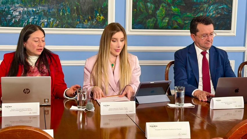 Ministra Diana Morales, sentada junto a su equipo de trabajo del Ministerio, mientras habla sobre el empalme.