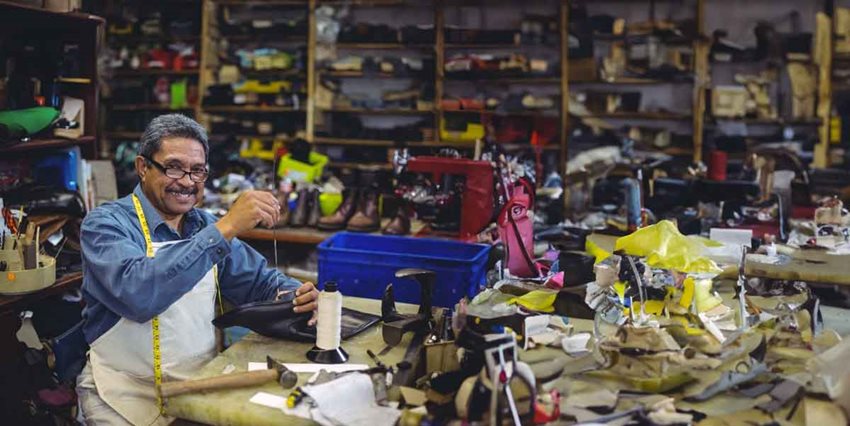 Hombre trabajando en taller de zapatos.