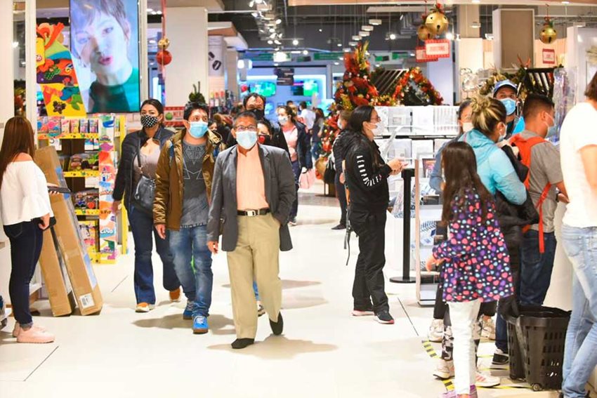 Personas caminando, con tapabocas, y comprando en almacenes debido al primer día sin IVA de 2021.