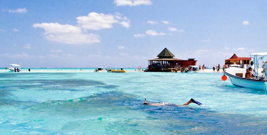 Turistas visitando y nadando playa de San Andrés.