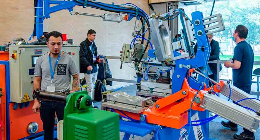 Tres hombres trabajando en un taller con máquinas.