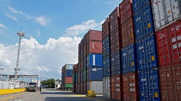 Contenedores de colores descargados y apilados en medio de calle de zona franca. - Gobierno colombiano aplicará un gravamen del 30 % a un grupo de productos provenientes de Ecuador