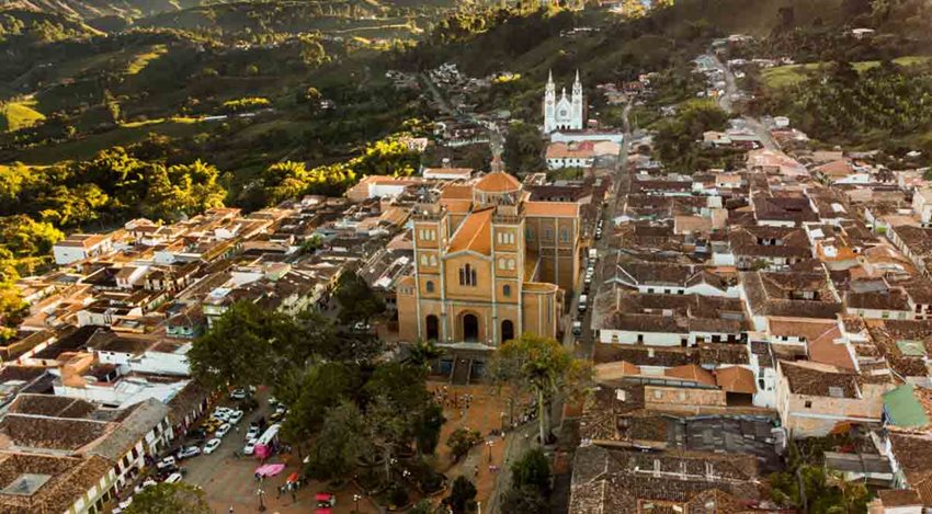 Fotografía desde el aire de iglesia, parque principal y demás pueblo alrededor.