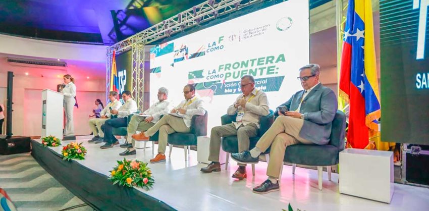 Funcionarios de los gobiernos de Colombia y Venezuela sentados en sillas en escenario, listos para dialogar.