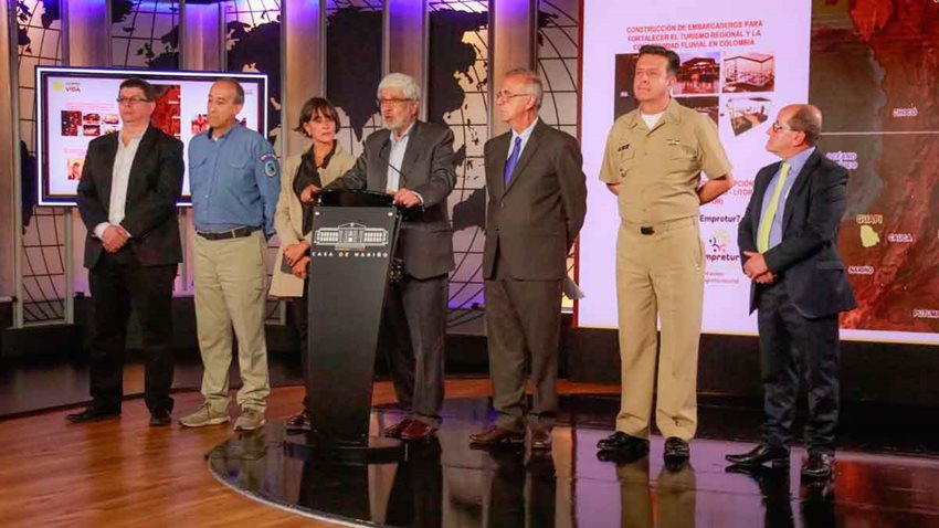 Ministro Germán Umaña junto a funcionarios del Gobierno, hablando desde el escenario a las cámaras.