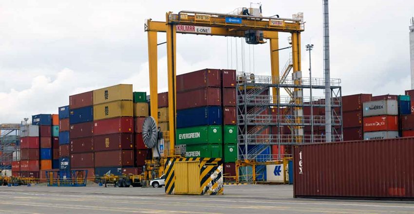Contenedores de colores descargados en medio de la calle de un puerto.