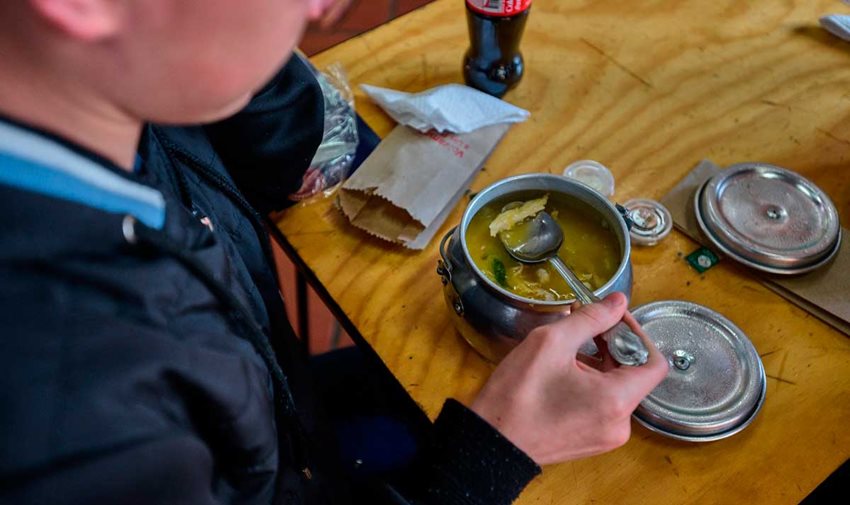 Un hombre consume una sopa.