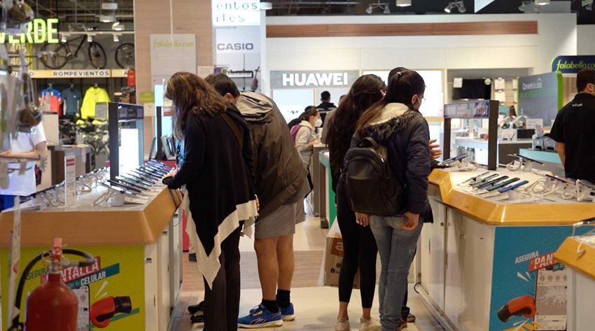 Personas en la sección de tecnología de almacén de cadena comprando productos en el día sin IVA.