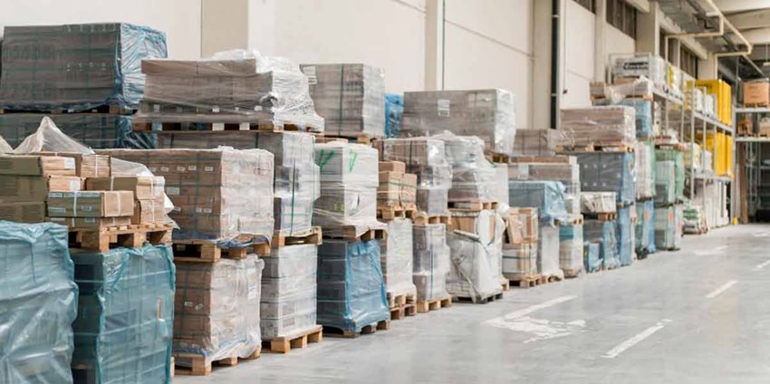 Cajas empacadas y apiladas contra una pared de una calle de zona franca.