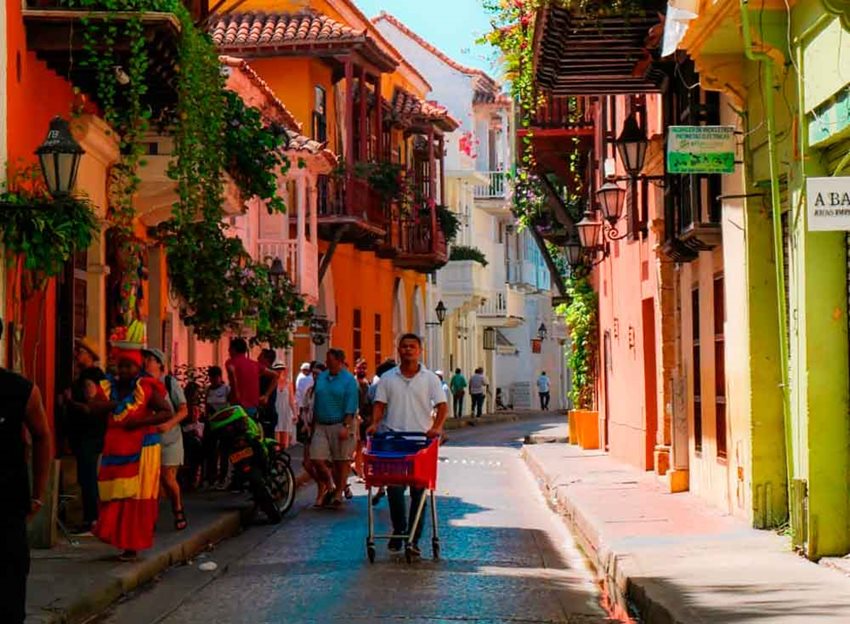 Turistas y cartageneros caminando por una calle de la ciudad histórica en Cartagena.