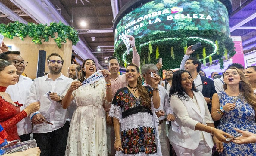Descripción: Hombres y mujeres celebrando en el estand de MinCIT en el Tianguis Turístico de México.