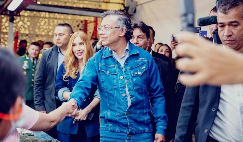 Descripción: Presidente Gustavo Petro y ministra Diana Morales saludando a personas en medio de una planta industrial.