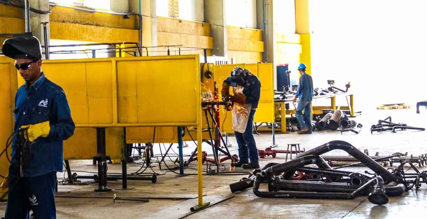 Tres hombres trabajando en soldadura.