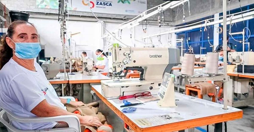 Mujer sentada frente a una máquina de coser.