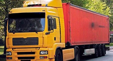 Camión amarillo con caja de carga rojo, estacionado en medio de la calle. - Gobierno de Colombia define productos cobijados por las medidas arancelarias frente a Ecuador 