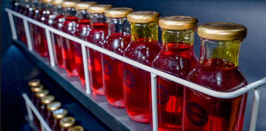 Aceite de palma color rojo envasado en botellas de vidrio.