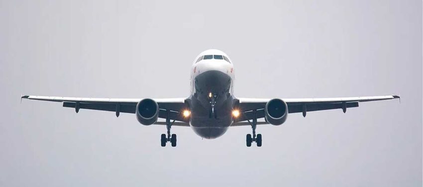 Avión blanco con gris tomando vuelo.