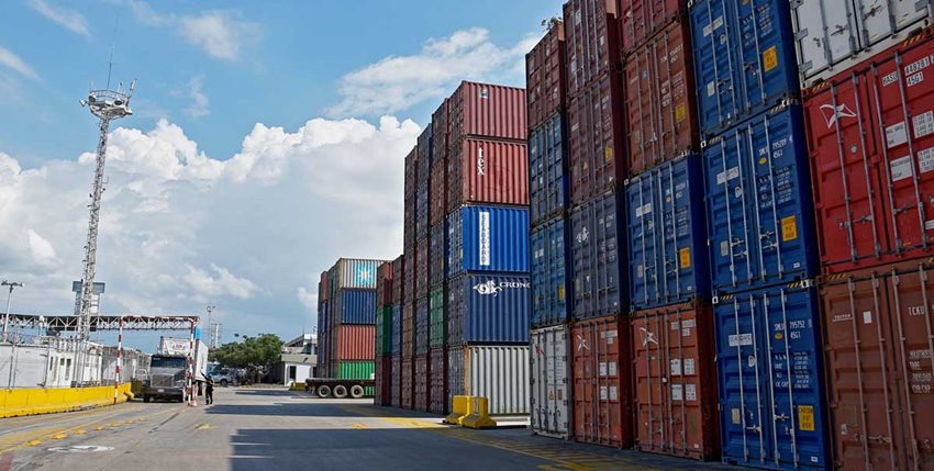 Contenedores de colores descargados en medio de la calle de un puerto.