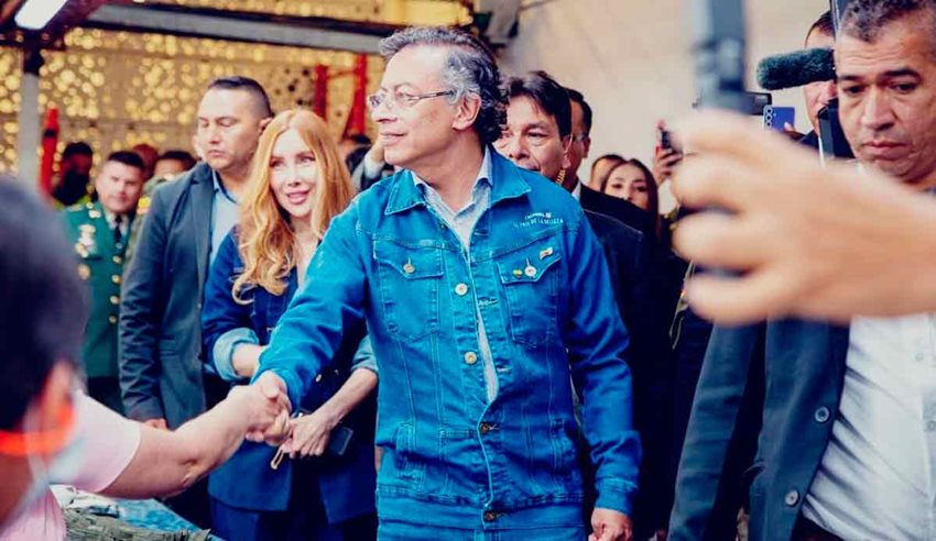 Presidente Petro, junto a la ministra Diana Morales, caminando y saludando a las personas.