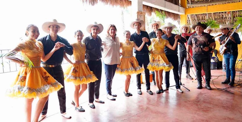 Hombres y mujeres con traje del joropo junto a la ministra María Ximena Lombana.