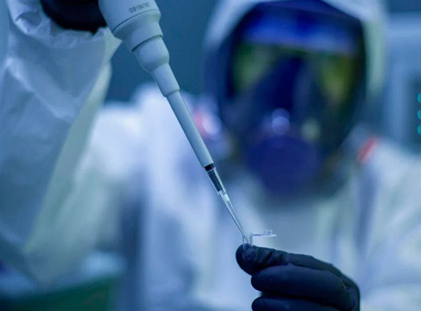 Científico, con traje de laboratorio, haciendo pruebas de vacunas.