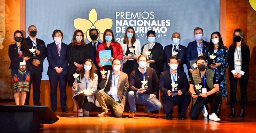 Ganadores de los Premios Nacionales de Turismo 2021 posando con sus galardones, junto a funcionarios.