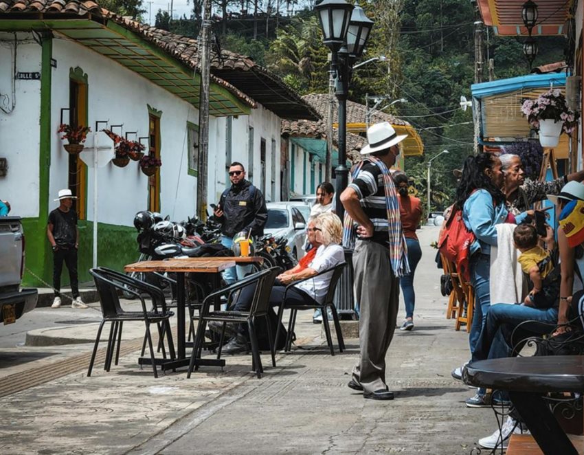 Turistas en medio de una calle de un pueblo, de día.