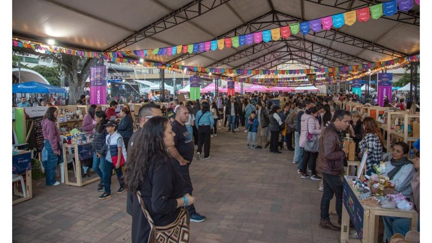 Personas caminando la feria y mirando los productos de los estands.