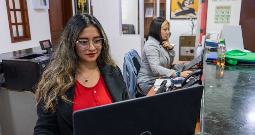 Dos mujeres trabajando en computadores.