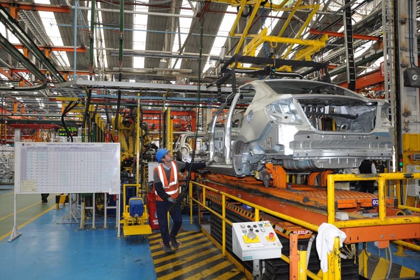 Trabajador operando máquina para ensamblar un automóvil.