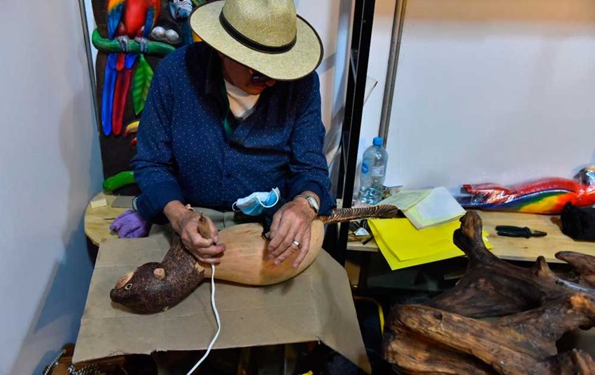 Artesano transformando madera en una escultura.