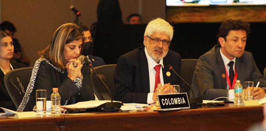 Ministro Germán Umaña, con traje y sentado, hablando en un micrófono a toda la audiencia.