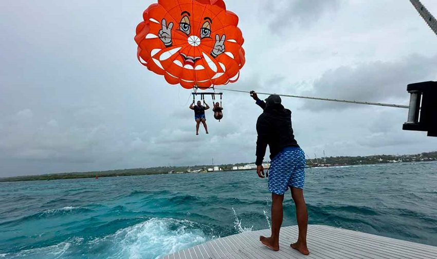 Dos personas haciendo parasail sobre el mar de San Andrés.