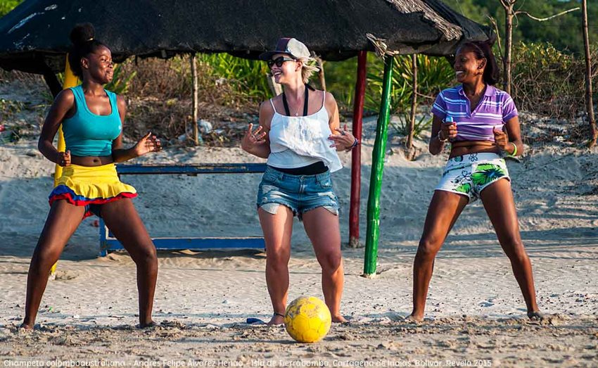 Tres mujeres bailan champeta en la playa.