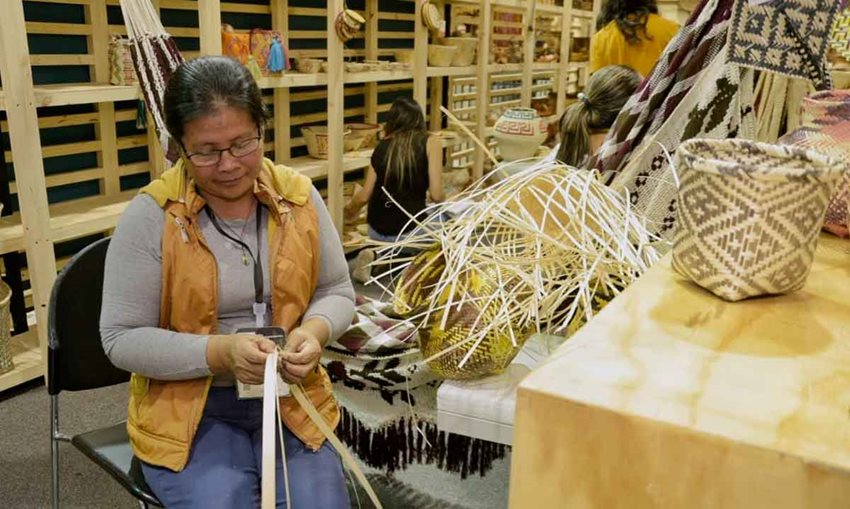 Artesana colombiana tejiendo canastos.