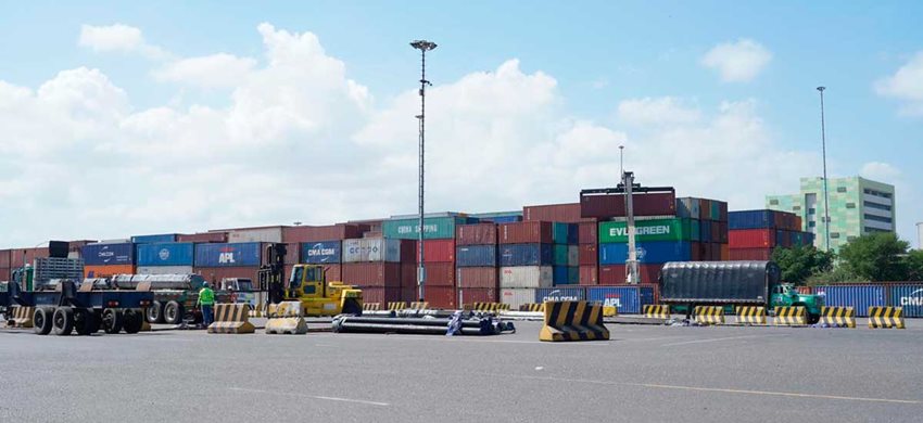 Contenedores de colores descargados en medio de la calle de un puerto.