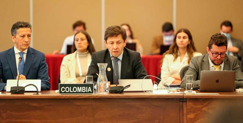 Viceministro de Comercio Exterior, Felipe Quintero, con traje y sentado en una mesa hablando por micrófono.