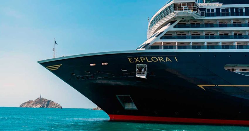 Fotografía de la parte lateral, del frente de un barco (crucero) negro con blanco, navegando en el mar.
