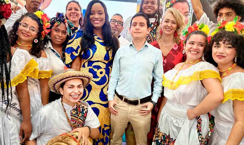 Descripción de la imagen: Hombres y mujeres posando para la foto, y algunos vestidos con trajes típicos colombianos.