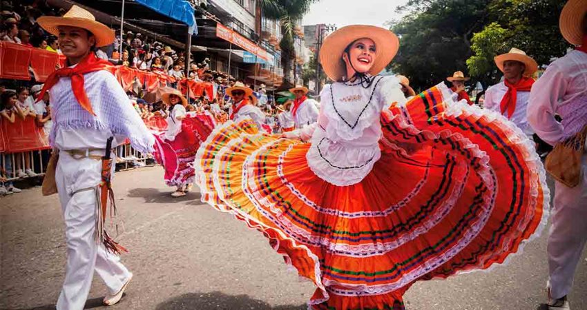 Descripción de la imagen: Mujer y hombre, con traje típico de Ibagué, desfilando por las calles.