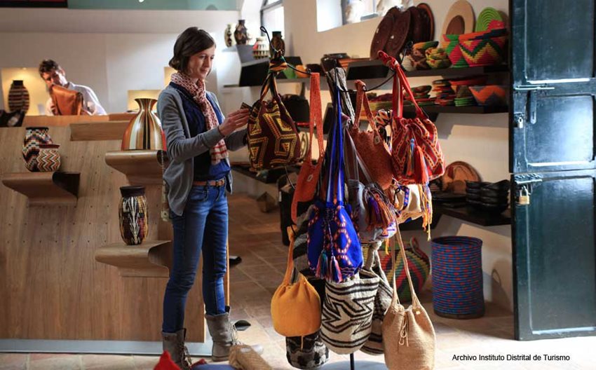 Fotografía de mujer comprando una mochila colombiana.