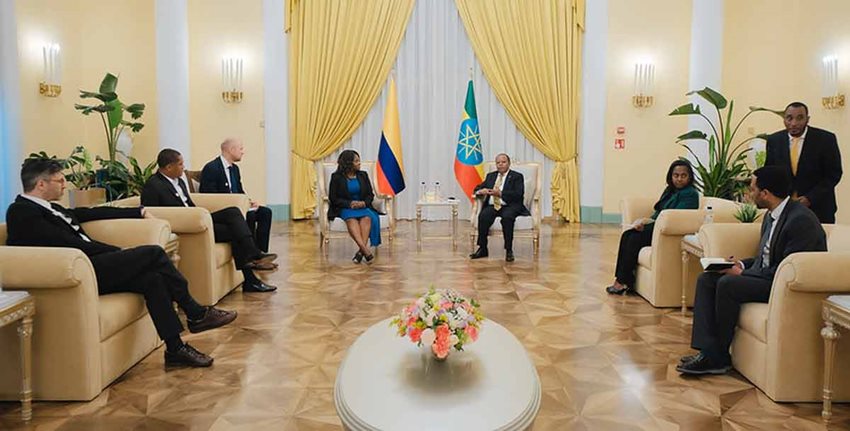 Hombres y mujeres, delegados oficiales de Colombia y África, reunidos dialogando en un gran salón.