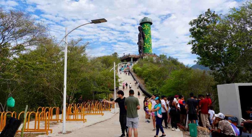 Fotografía de paisaje, en medio del parque, y personas caminando alrededor.